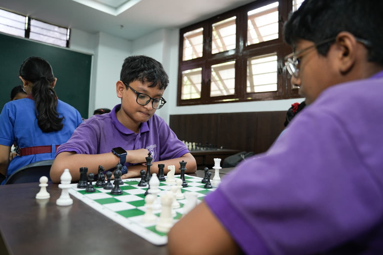 Children gathered around a chess board